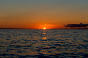 Beautiful sunset on sky with clouds at sea