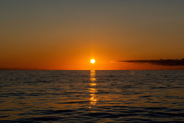 Beautiful sunset on sky with clouds at sea