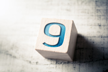 Number 9 On A Wooden Block On A Table