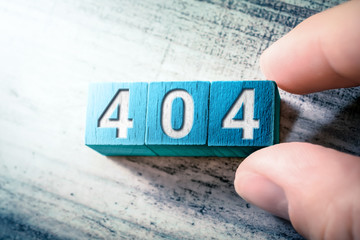 Error Code 404 On Blue Wooden Blocks On A Table, Arranged By A Hand