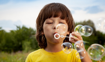 happy boy play in bubbles outdoors