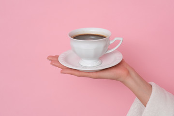 Obraz na płótnie Canvas Coffe please. Female hand holding a cup of coffee isolated on pink background. Time to charge battery.