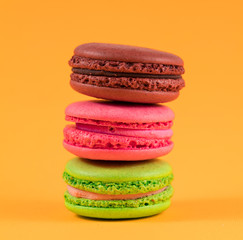 three colored macaroon on a yellow background