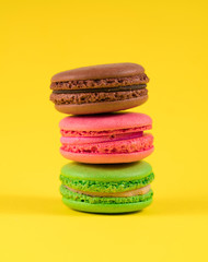 three colored macaroon on a yellow background