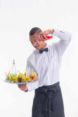 Young waiter holding a tray and mixing liquors