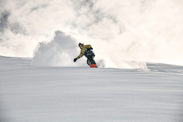 Freerider on a snowboard slipping on a snowy mountain side