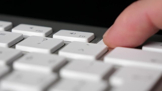 Finger pressing repeatedly the F12 function key on keyboard. Close-up