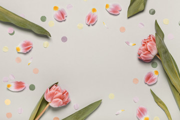 Pink tulips and colorful confetti on a beige background. Place for your text, tinting image