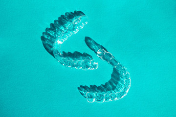Invisible aligners teeth brackets on blue background