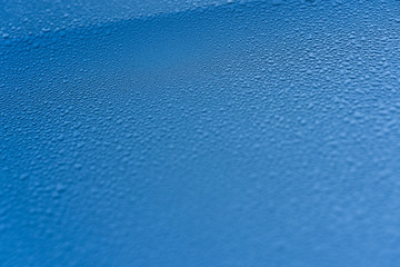 Raindrops on the hood of the car. Close-up.