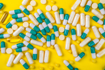 colorful pills and tablets on yellow background