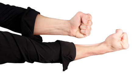 male hands in rolled up sleeves of a black shirt with clenched fists