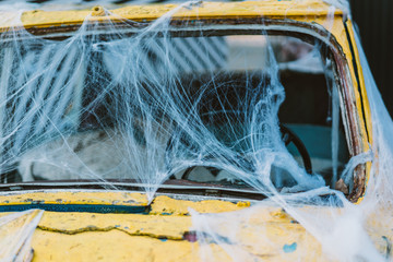 Old retro yellow taxi decorated with cobwebs