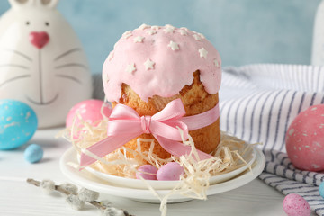 Easter composition with Easter cake and eggs on white wooden table against blue background