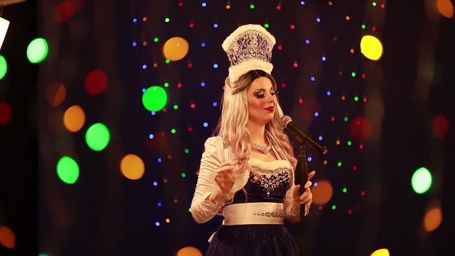 Video clip young woman singer in a New Year&rsquo;s costume Snow Maiden sings a song in stage light