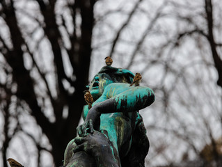 Ancient bronze statue of the streets of Vienna with three sparrows on top..