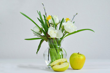 Glass vaza with a bouquet of spring flowers and apples.Bunch of pussy willow branches with catkins and white roses.Spring card for Mother's Day, Women's Day. copy space.