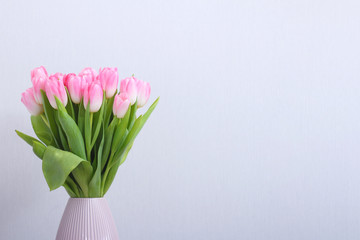 Pink tulips flowers bouquet in vase on grey background. Women, Mothers, Valentine's Day, birthday, spring greeting card. Copy space.