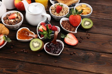 Breakfast served with coffee, orange juice, croissants, cereals and fruits. Balanced diet. Continental breakfast with granola and fruits