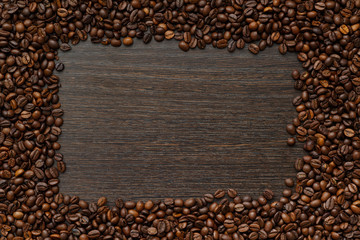 coffee beans on a wooden surface along the contour. a place for a label