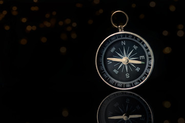 Compass on dark black background with copy space using as direction