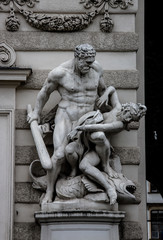 Sculpture of Hercules with a mace fighting another person at the entrance to the Imperial Hofburg Palace.