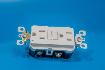 Close-up shot of an electrical outlet with a fuse against a blue background