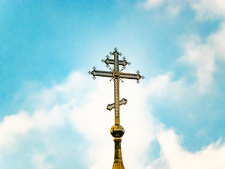 Orthodox church cross on a background of blue sky with clouds. Easter. Christmas. Place for text....