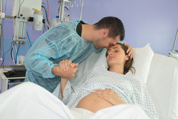husband supporting pregnant wife at home