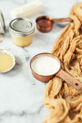 Jars of honey butter with ingredients on marble background