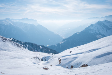 Fototapeta na wymiar Morning mountain landscape at a ski resort Campitello di Fassa Italy. Sun and haze in the mountains