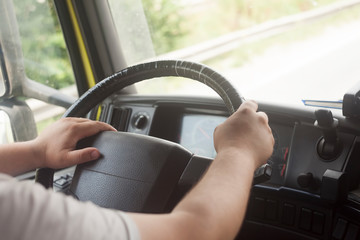 man with hands on truck steering wheel. driving on the road