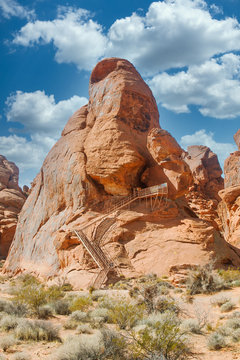 A Metal Staircase Climbing Up A Red Rock Canyon Toward Carvings