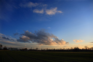 Chmury, obłoki na błękitnym niebie w czasie zachodu słońca.