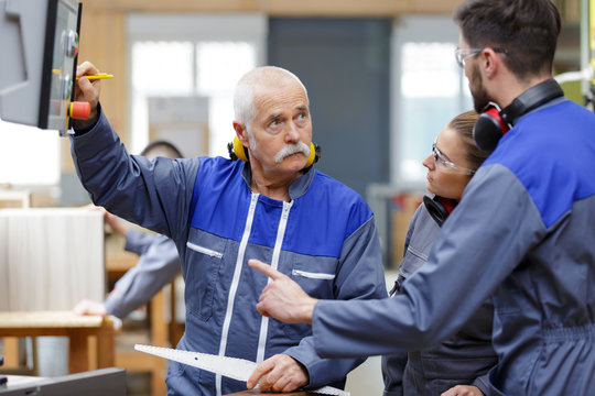 carpenter trainees learning with boss about wood measurement