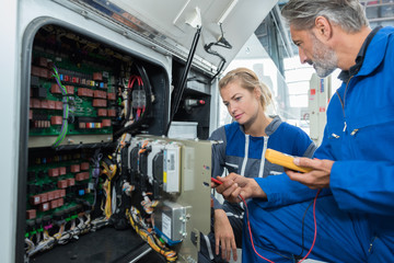 motor mechanics testing the fuses on a bus
