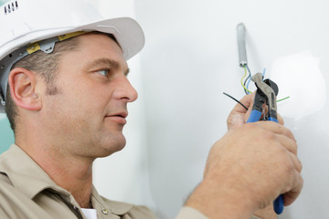 worker repairs a plug with a screwdriver