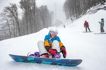 Fototapeta na wymiar Young woman snowboarder in mountains