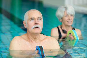 Fototapeta premium happy senior couple swimming in the pool