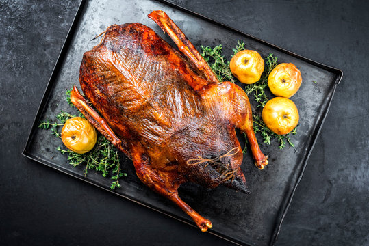 Traditionell gegrillte Weihnachtsgans gef&uuml;llt mit &Auml;pfel und Kr&auml;uter als Draufsicht auf einem rustikalen Metall Tablett