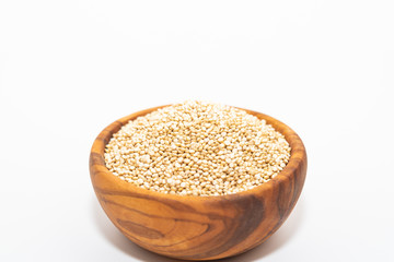 Raw quinoa in a wooden bowl isolated on white background with copy space