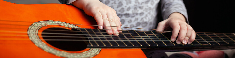 children's handles on strings and neck.learning acoustic guitar panorama