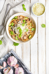 Whole wheat spaghetti with sauteed mushrooms garlic and zucchini, topped with grated cheese and basil leaves