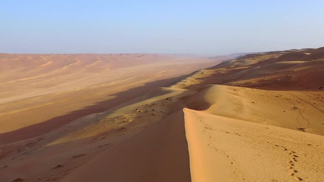 A man taking a self-timer photo alone in the desert, Oman