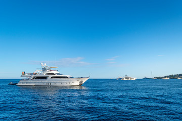 Fototapeta na wymiar A cloudless summer day as luxury yachts dot the Mediterranean sea at Saint-Jean-Cap-Ferrat on the southern coast of France on the French Riviera.