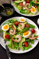 Healthy fresh vegetable salad with shrimps, boiled eggs and avocado