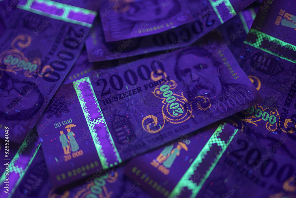 Wall mural Check the authenticity of money. 20000 Hungarian forint banknote in UV light to verify authenticity of the money. Image may contain noise , grains.