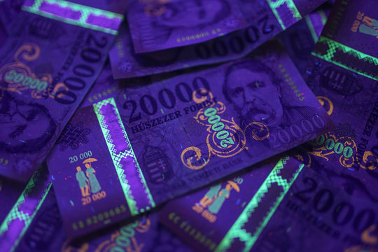 Check the authenticity of money. 20000 Hungarian forint banknote in UV light to verify authenticity of the money. Image may contain noise , grains.