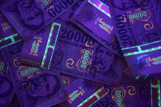 Check the authenticity of money. 20000 Hungarian forint banknote in UV light to verify authenticity of the money. Image may contain noise , grains.