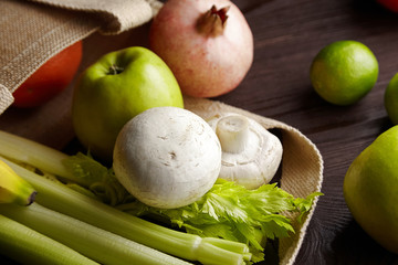 Fresh fruits and vegetables on wooden table, mushroom and apple